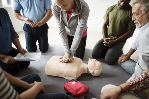Group of adults practicing chest compressions on CPR manikins