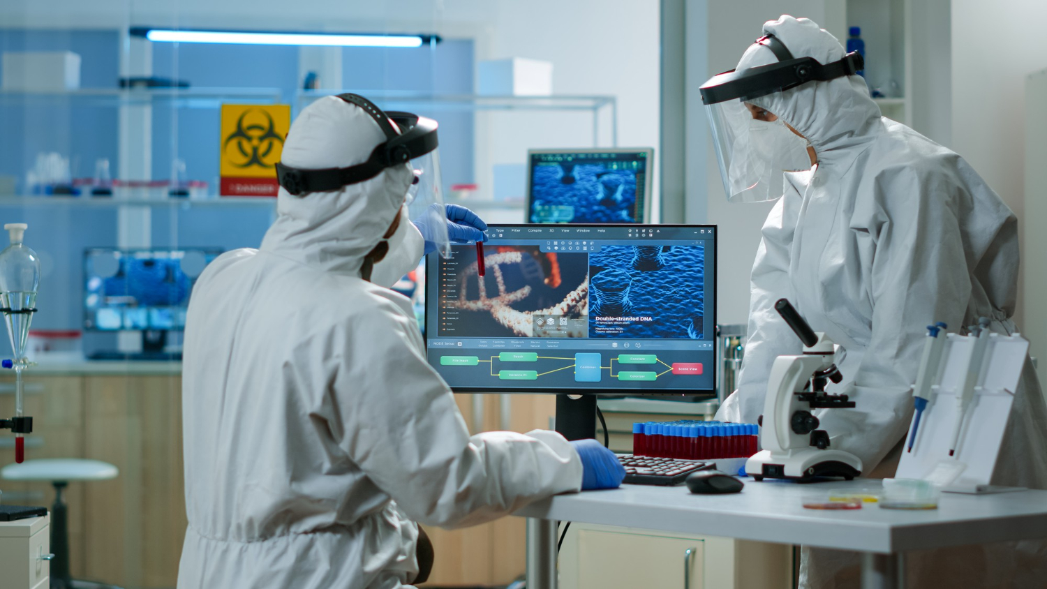 Biotech workers in PPE participating in safety response training with digital interface