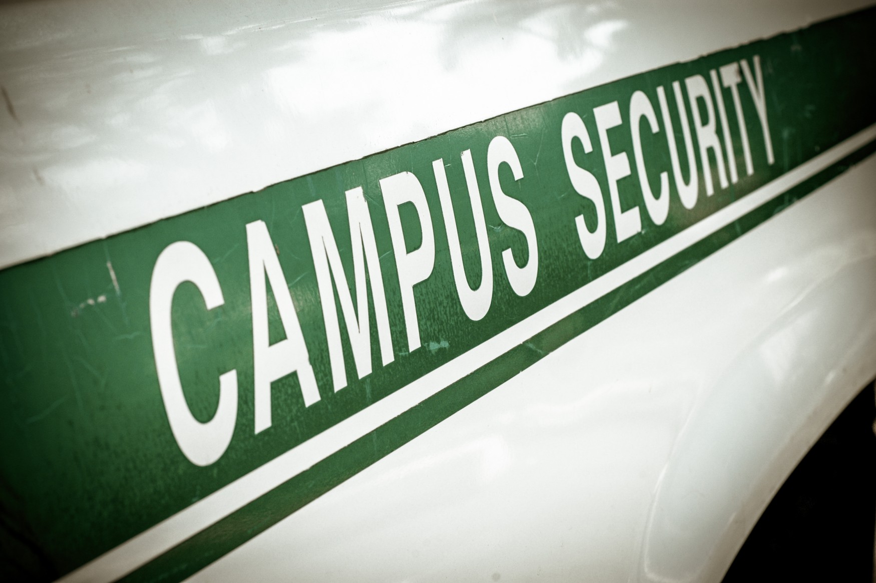 Campus security vehicle with green lettering parked on university grounds