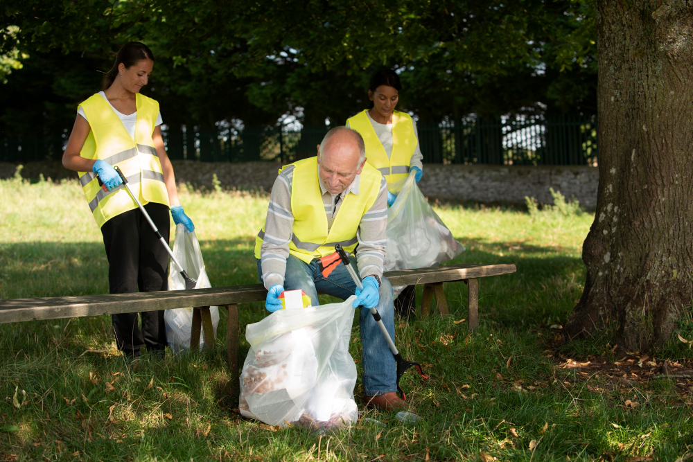 “Municipality workers wearing safety vests cleaning park area.