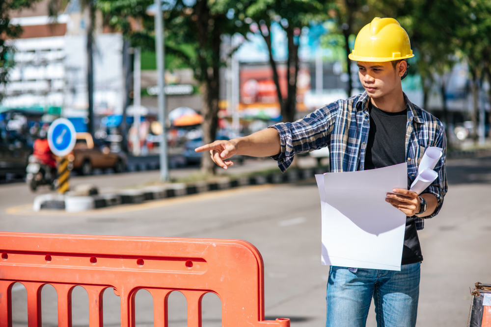 Municipality engineer wearing hard hat pointing during city safety inspection.