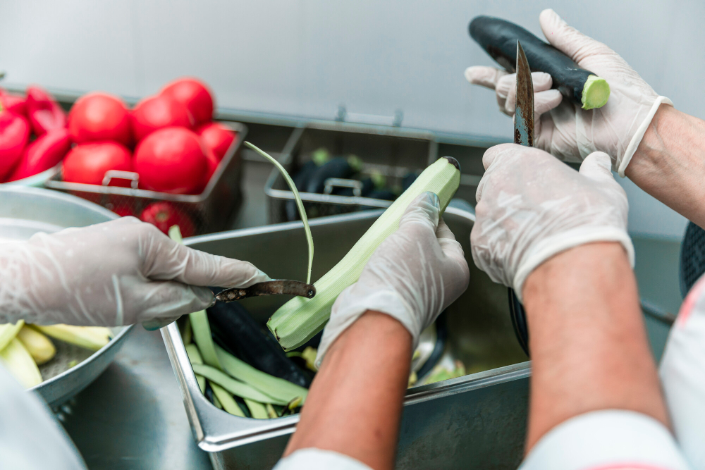 Workers handling fresh vegetables safely in a kitchen environment – Safety Is A Mindset